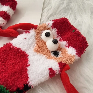 Close-up of fluffy coral fleece Christmas socks featuring a 3D cute cartoon mascot detail