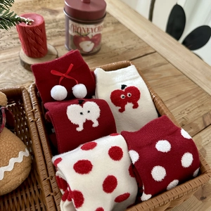 Close-up of festive red and white thermal rabbit wool socks in a woven basket