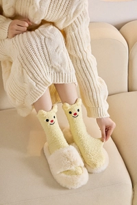 Detail von weichen Korallenvlies-Socken mit süßen 3D-Ohren und Stickerei auf Gelb