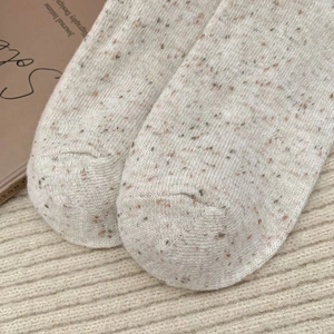 Détail macro de la texture en fil moucheté et de la pointe renforcée des chaussettes d'hiver