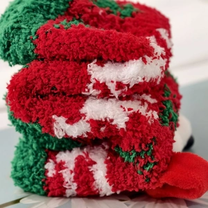 Detailed close-up of fluffy Christmas coral fleece socks with red and green stripes