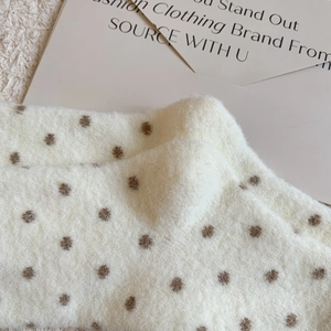 Gros plan de chaussettes thermiques en polaire blanc crème à motif de pois marrons