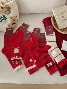 Flat lay of festive red and white socks with bow details and cozy knit patterns