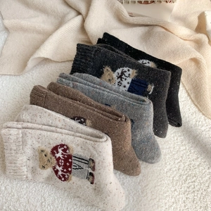 Detail showing five pairs of thick winter knit socks with cute cartoon bear jacquard patterns