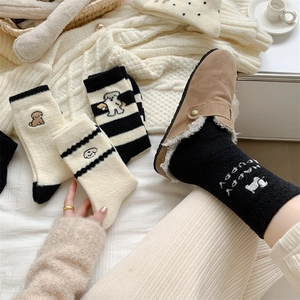 Close-up of thick winter socks with embroidered puppy designs and warm fleece texture