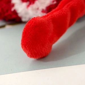 Close-up of soft coral fleece material and thick texture on red Christmas socks