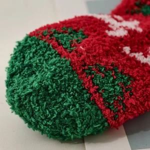 Close-up of soft coral fleece texture on Christmas themed warm socks in red and green