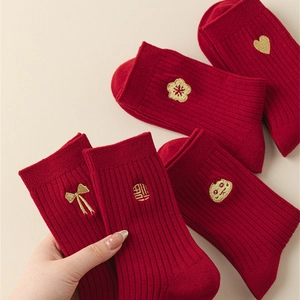 Detailed view of red cotton socks with gold embroidery featuring festive Chinese patterns