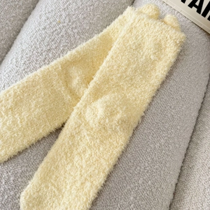 Nahaufnahme gelber Korallenvlies-Socken mit ultra-weicher Textur und warmem Langrohr-Design