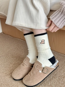 Detail of warm white thermal socks with cute brown puppy embroidery and dark accents