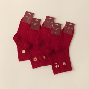 Detail of red cotton socks with gold zodiac embroidery and New Year festive patterns