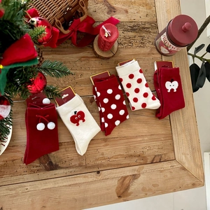 Close-up of five pairs of red and cream festive knit socks with cute holiday embroidery