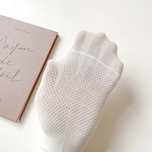 Close-up of white breathable mesh texture on lightweight summer athletic socks