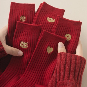 Close-up of red festive socks with gold embroidery and ribbed cotton texture for New Year