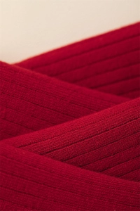 Detail of red vertical ribbed knit cotton fabric showing texture and stitching for socks