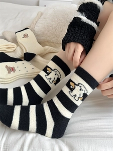 Detailed close-up of thick winter socks featuring cute white dog embroidery on striped fabric