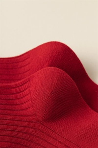 Macro shot of red knit socks featuring precise ribbing and reinforced heel stitching