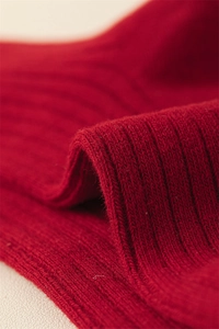 Macro shot of vibrant red rib-knit cotton fabric texture for festive zodiac socks