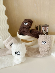 Dettagli di calze spesse in peluche a forma di cartone animato con grandi occhi