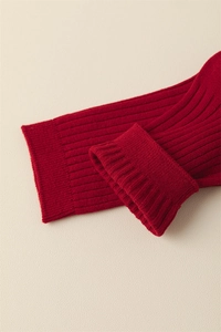 Detail of red ribbed knit cotton socks showing the thick elastic texture and cuff