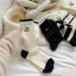 Close-up of soft coral fleece socks with cute puppy embroidery and HAPPY PUPPY text