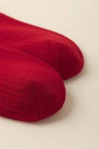 Detail shot of red cotton socks showing hand-linked toe seams and vertical knit texture