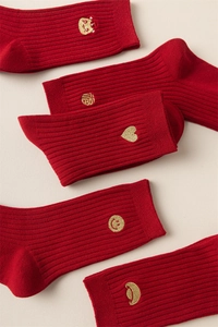 Detail of red festive socks with golden embroidery of Fu character and lucky symbols