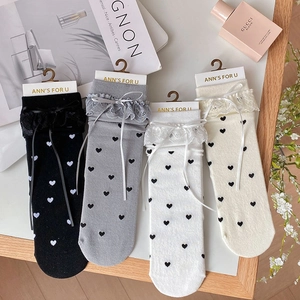 Detail of four pairs of Lolita style socks with lace ruffles and ribbon bows