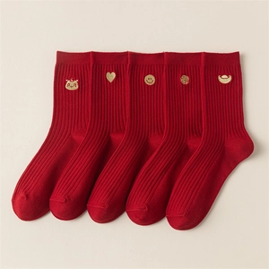 Detail view of 5 pairs of red cotton socks with festive gold embroidery motifs