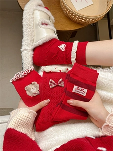 Detail of red festive socks with bow and heart embroidery in cozy home setting