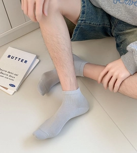 Detail of light grey low-cut men's socks with breathable mesh texture and ribbed cuffs