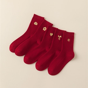 Close-up of red cotton socks featuring golden zodiac and fortune character embroidery