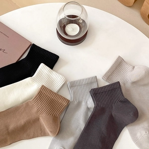 Flat lay of colorful ribbed cotton crew socks on a table with lifestyle props