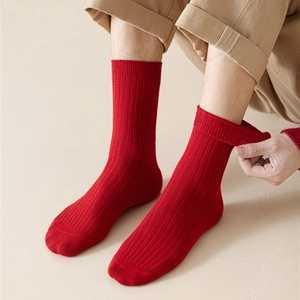 Detailed view of red ribbed cotton crew socks for Chinese New Year on feet with warm lighting