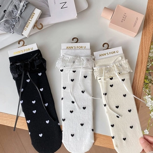 Detailed view of Lolita style socks with lace edges and ribbon bows in black and white