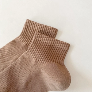 Detail of brown cotton athletic socks showing high-elastic ribbing and breathable mesh knit