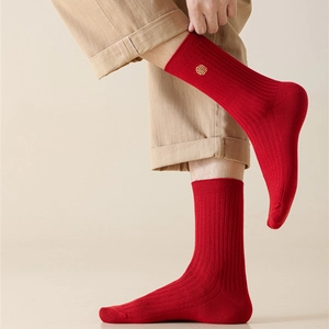 Detailed close-up of red ribbed crew socks with golden traditional embroidery patterns