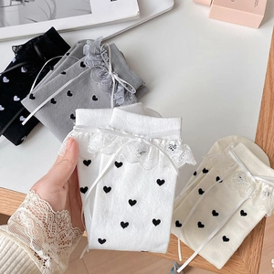 Detailed close-up of white Lolita socks with lace trim and elegant ribbon bow detail