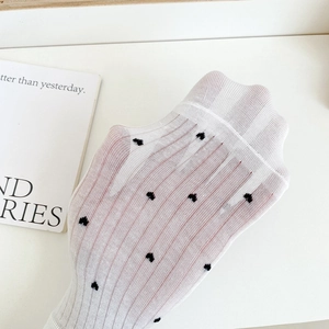 Close-up of white mesh boat socks with black heart pattern showing breathable texture