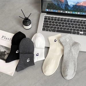 Detail of five pairs of cotton athletic socks featuring embroidered G letter and ribbed cuffs
