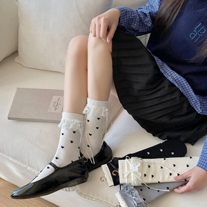 Detail view of heart print socks with white lace trim and delicate silk ribbon bows