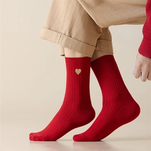 Detail of red crew socks with gold heart embroidery and vertical ribbed texture