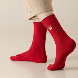 Detail of red festive crew socks featuring classic ribbed texture and small cute embroidery