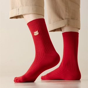 Detail of red ribbed cotton socks with festive cartoon embroidery on the ankle side