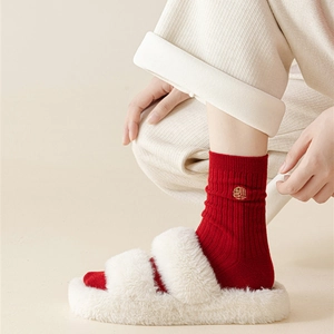 Detail of red festive cotton socks with gold Fu embroidery and ribbed knit texture