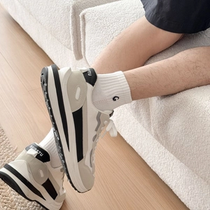 Close-up of stylish beige and grey patchwork sneakers with thick anti-slip soles
