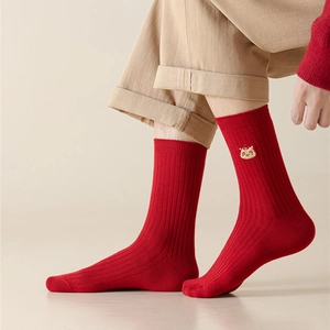Detail of red ribbed cotton socks with yellow cartoon embroidery and a snug fit
