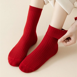 Close-up of flexible red ribbed cotton socks showing elastic cuff stretch and texture