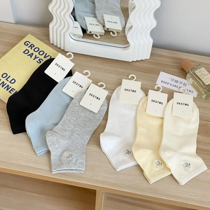 Dettaglio di sei paia di calze in cotone con ricami di elefanti in vari colori pastello