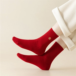 Detailed close-up of red cotton socks with gold Fu embroidery and ribbed knit texture